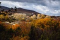 Autumn rural landscape with yellow trees in the highlands with an elevator in the background