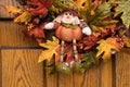 Autumn scarecrow doll on door wreath