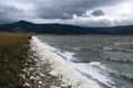 Wind swept landscape with spume along water`s edge