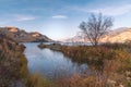 Autumn scene of lake and mountains with autumn grasses and leaves with warm light of sunset Royalty Free Stock Photo