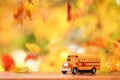 Orange school bus surounded by falling leaves Royalty Free Stock Photo