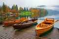 Autumn scenery with boats moored on Bled lake at foggy day Royalty Free Stock Photo