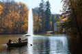 Autumn scenery in the National Park. Fountain on pond, people on the boat Royalty Free Stock Photo