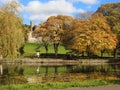 Autumn scenery with park pond and castle behind trees. Royalty Free Stock Photo