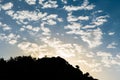 An autumn scenery of the sun rising behind the Mediterranean mountain ridge. Blue and bright yellow sky with clouds. Royalty Free Stock Photo