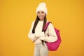 Autumn school holiday. Back to school. Teenager schoolgirl in autumn clothes on yellow isolated studio background.