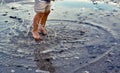 Autumn seashore. A child girl jumps barefoot through the sea puddles. Children`s rest. Happy moments of child