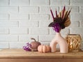 Autumn season concept with dried bouquet in modern vase and pumpkin decoration on wooden table over brick wall background Royalty Free Stock Photo