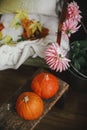 Autumn season in countryside, rural slow life. Beautiful pumpkins on wooden bench, colorful dahlias bouquet in metal bucket and