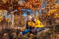 Autumn season fun. Senior couple hugging sitting in park. Man and woman relaxing outdoors Royalty Free Stock Photo