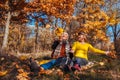 Autumn season fun. Senior couple throwing leaves sitting in park. Man and woman relaxing outdoors Royalty Free Stock Photo