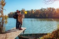 Senior family couple walking by autumn lake. Happy man and woman enjoying nature and hugging on pier Royalty Free Stock Photo