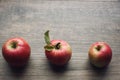 Autumn season still life with three apples over rustic wooden background. Copy space, horizontal. Royalty Free Stock Photo