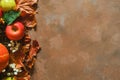 Autumn seasonal fruits, dried flowers and maple leaves on brown backdrop. Copy space.