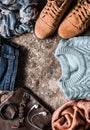 Autumn set of women`s clothing - suede shoes, jeans, knitted pullover, scarf, shoulder bag, accessories on a wooden background, t Royalty Free Stock Photo