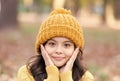 Autumn skin care. Little child wear hat on autumn landscape. Small girl touch clean pure skin. Organic cosmetics for