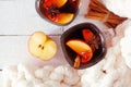 Autumn spiced tea with apples and cinnamon, top view on a white wood background with cozy blanket