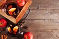 Autumn spiced tea with apples and pomegranates, top view side border with copy space on a wood background
