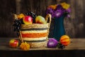 Autumn still life with apples and grapes in a basket. Purple asters and marigolds in a blue vase, pumpkin.