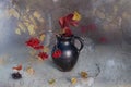 Branches with red berries in a vase.Autumn still life berries fireplaces, yellow leaves in a vase on a brown background