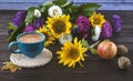 Autumn still life with a bouquet of asters and sunflowers, a blue cup of coffee, an apple and nuts Royalty Free Stock Photo