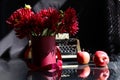 Autumn still life: a bouquet of burgundy dahlias, an old typewriter, red apples on the table, reflection from objects, dark Royalty Free Stock Photo