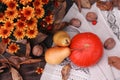 Autumn still life. Bouquet of orange chrysanthemums, pumpkin, pears and nuts on a wooden table. View from above. Royalty Free Stock Photo