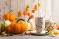 Autumn still life with cup of tea, pumpkins,flowers and candles on table.Thanksgiving day or halloween concept Royalty Free Stock Photo