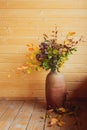 Autumn dried bouquet in ceramic vase on wooden background Royalty Free Stock Photo