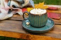 Autumn still life with hot coffee with marshmallows on the street. Side view. A cup of coffee on a diagonal wooden Royalty Free Stock Photo