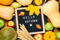 Autumn still life image with melon, apples, pears, rye, pumpkins, colorful foliage and letter board with words Hello Autumn