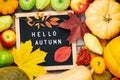 Autumn still life image with pumpkins, ashberry, pears, apples, colorful foliage and letter board with words Hello Autumn