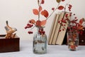 Autumn still life with leaves bouquet, books and decorative bird.