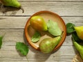 Autumn still life with pears and green leaves on a wooden table Royalty Free Stock Photo