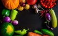 Autumn still life with pumpkin, watermelon, and a variety of colorful vegetables on black wooden background. Happy Thanksgiving