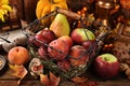 Autumn still life with seasonal fruits in wire basket on wooden table Royalty Free Stock Photo