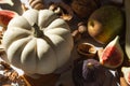 Autumn still-life with white pumpkin, sliced figs, walnuts and pears on wooden cutting board. Healthy eating concept. Royalty Free Stock Photo