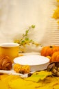 Autumn still life in yellow-orange tones: a white knitted plaid and leaves, close-up empty podium white scene