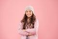 Autumn style. cheerful child pink background. knitted accessory. small girl winter hat. kid fashion. trendy girl look Royalty Free Stock Photo