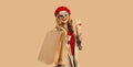 Autumn style outfit, portrait of beautiful happy smiling young woman with shopping bags wearing red french beret hat, gray coat Royalty Free Stock Photo