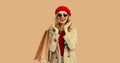 Autumn style outfit, portrait of beautiful happy smiling young woman with shopping bags wearing red french beret hat, gray coat Royalty Free Stock Photo