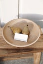 Autumn, summer fruit food still life. Yellow pears, wooden bowl on table in sunset light. Blurred beige wall background