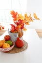 Autumn sunny kitchen with vegetables, pumpkin and yellow leaves on white table, copy space Royalty Free Stock Photo