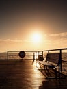 Autumn sunny misty morning in harbor. Touristic mole, wet wooden floor above sea. Royalty Free Stock Photo