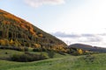 Autumn sunset orange green vibrant landscape rural power lines clouds blue sky hillside forest trees beautiful bulgaria Royalty Free Stock Photo