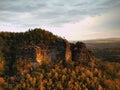 Autumn sunset view over sandstone rocks to fall colorful valley of Bohemian Switzerland. Sandstone peaks in forest. Royalty Free Stock Photo