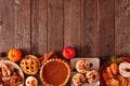 Autumn table scene bottom border of pies, appetizers and desserts. Top view over a wood background with copy space. Royalty Free Stock Photo