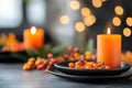 Autumn table setting with candles, black plates, and seasonal foliage Royalty Free Stock Photo