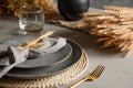 Autumn table setting with dry yellow oak leaves, fall decoration on grey. Thanksgiving day Royalty Free Stock Photo