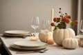 Autumn Table Setting Featuring Mini White Pumpkins, Ceramic Plates, Candles, And Napkins